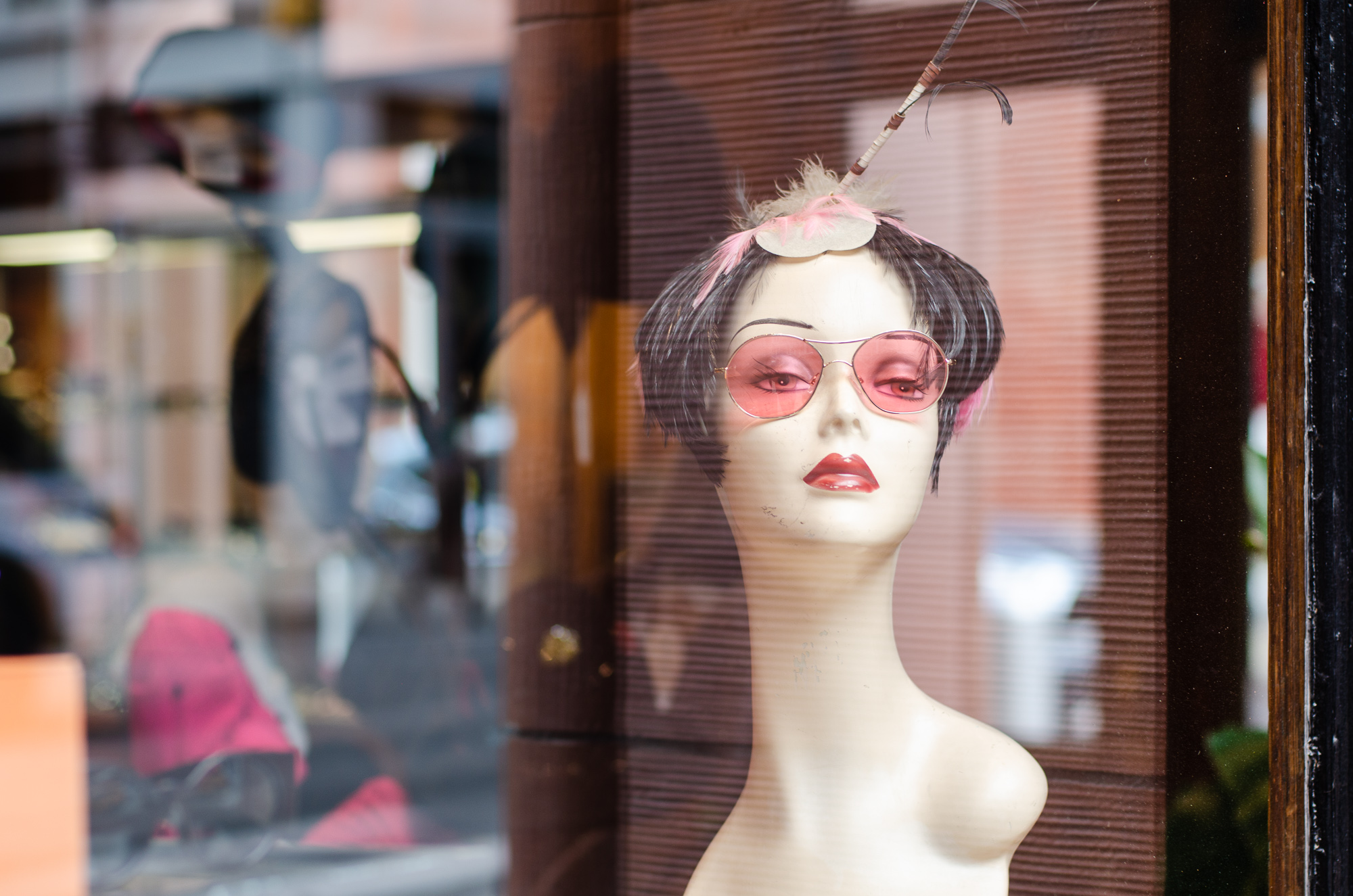 Mannequin head wearing sunglasses in store window