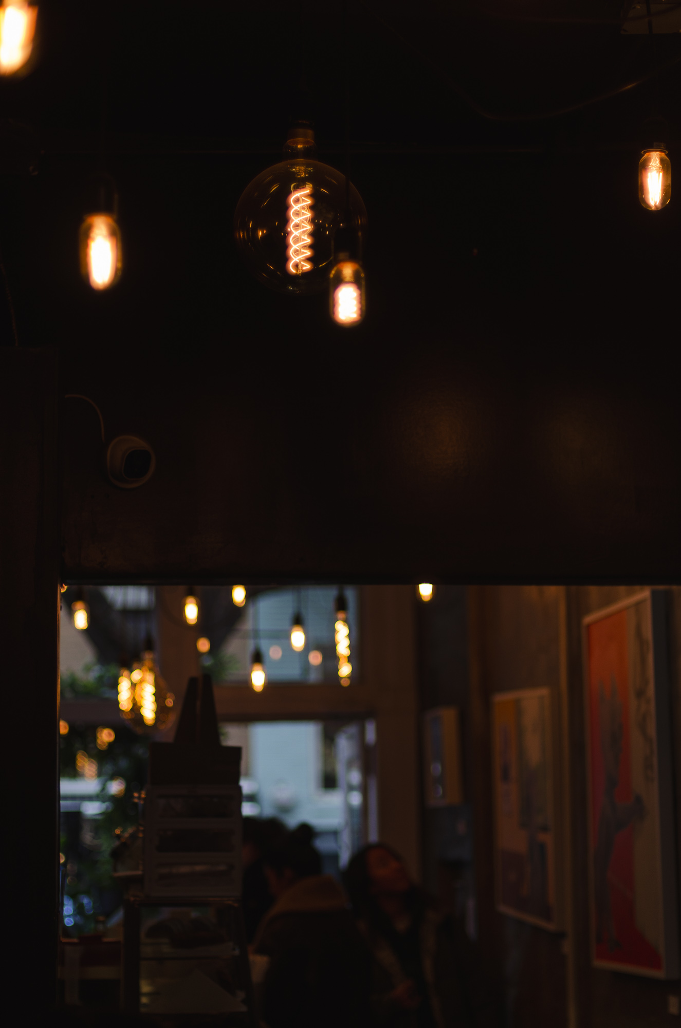Edison bulbs and artwork on the walls of a coffee shop in SoHo